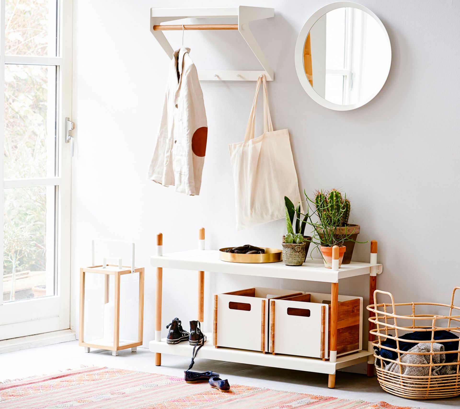 Heller Flur mit Cane-Line City Rack Garderobe, Kleiderstange, Spiegel und Aufbewahrungskörben.