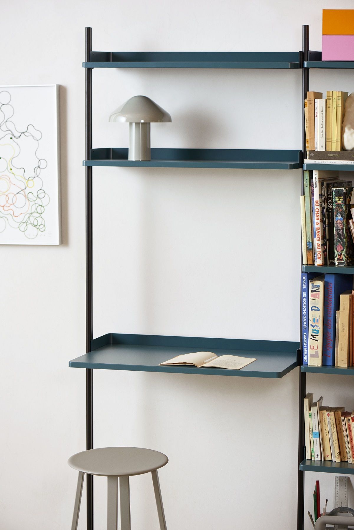 Helles Interieur mit Pier System Regal von Hay, zwei Säulen, Ablage, Bücher und Lampe.