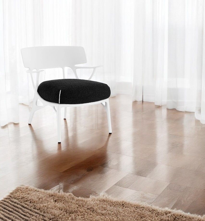 Weißer A.I. Lounge Sessel von Kartell mit schwarzem Sitzkissen vor hellem Hintergrund. Designermöbel für Wohnzimmer.