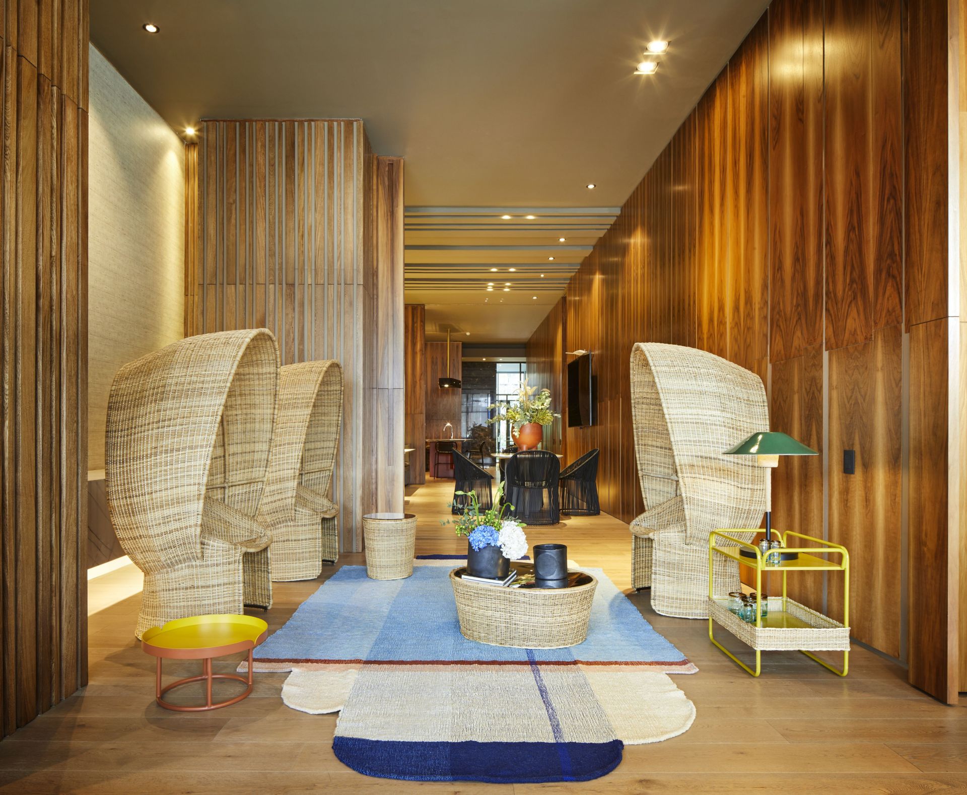 Cartagenas Ames Sessel aus Naturrohr im modernen Wohnzimmer mit Teppich und Beistelltischen.