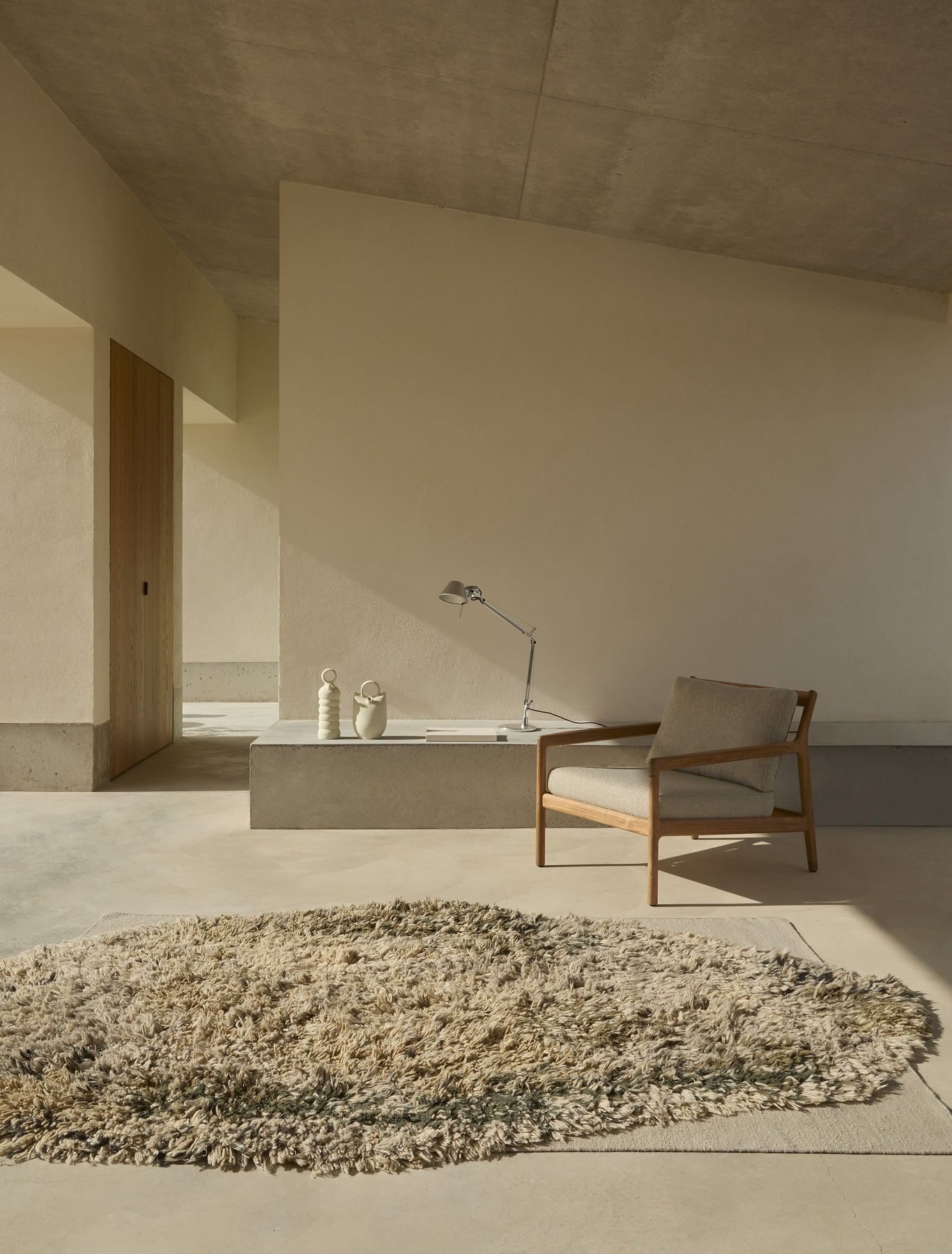 Beiger Alga Rug Teppich von Nanimarquina in minimalistischem Wohnzimmer mit Sessel und Dekoration.