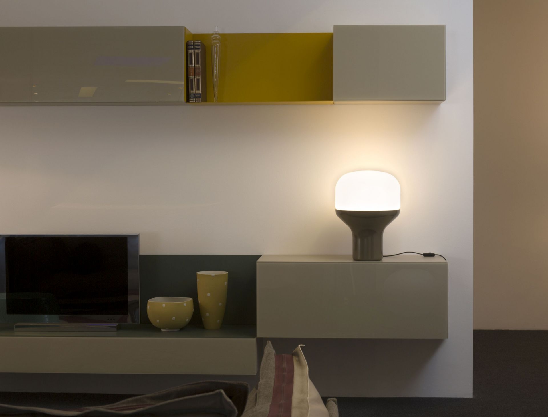 Delux Tischleuchte Sandgold leuchtet auf einem Sideboard. Moderne Lampe für Wohnzimmer und Schlafzimmer.