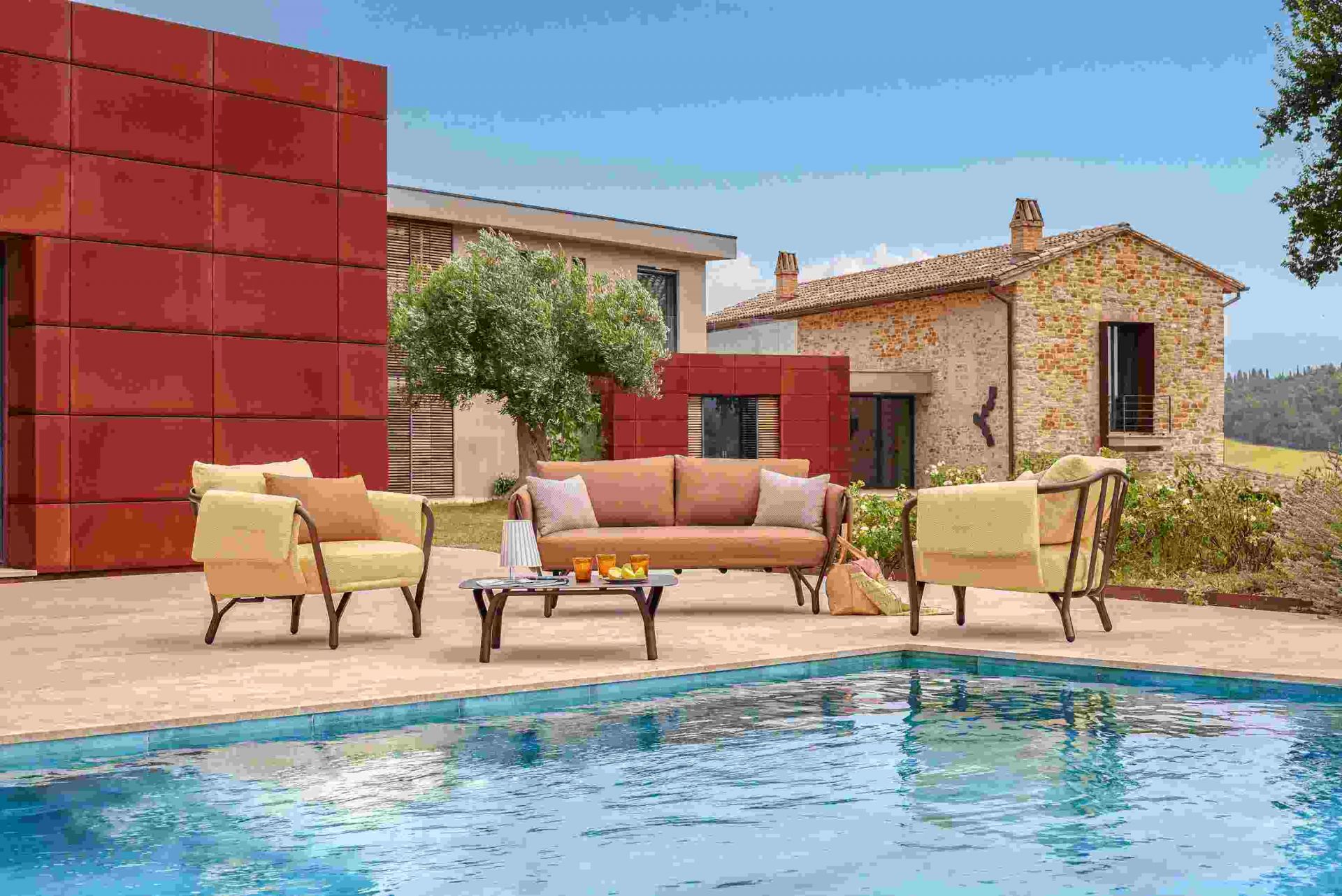 Angel niedriger Tisch von Emu neben Pool, Teil einer Outdoor-Lounge-Gruppe mit Sofa und Sesseln.