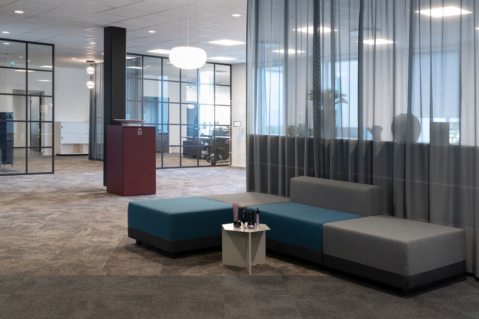 Büroaufnahme mit rotem Exhibit Bin Mülleimer für Mülltrennung von Mizetto im modernen Büro.