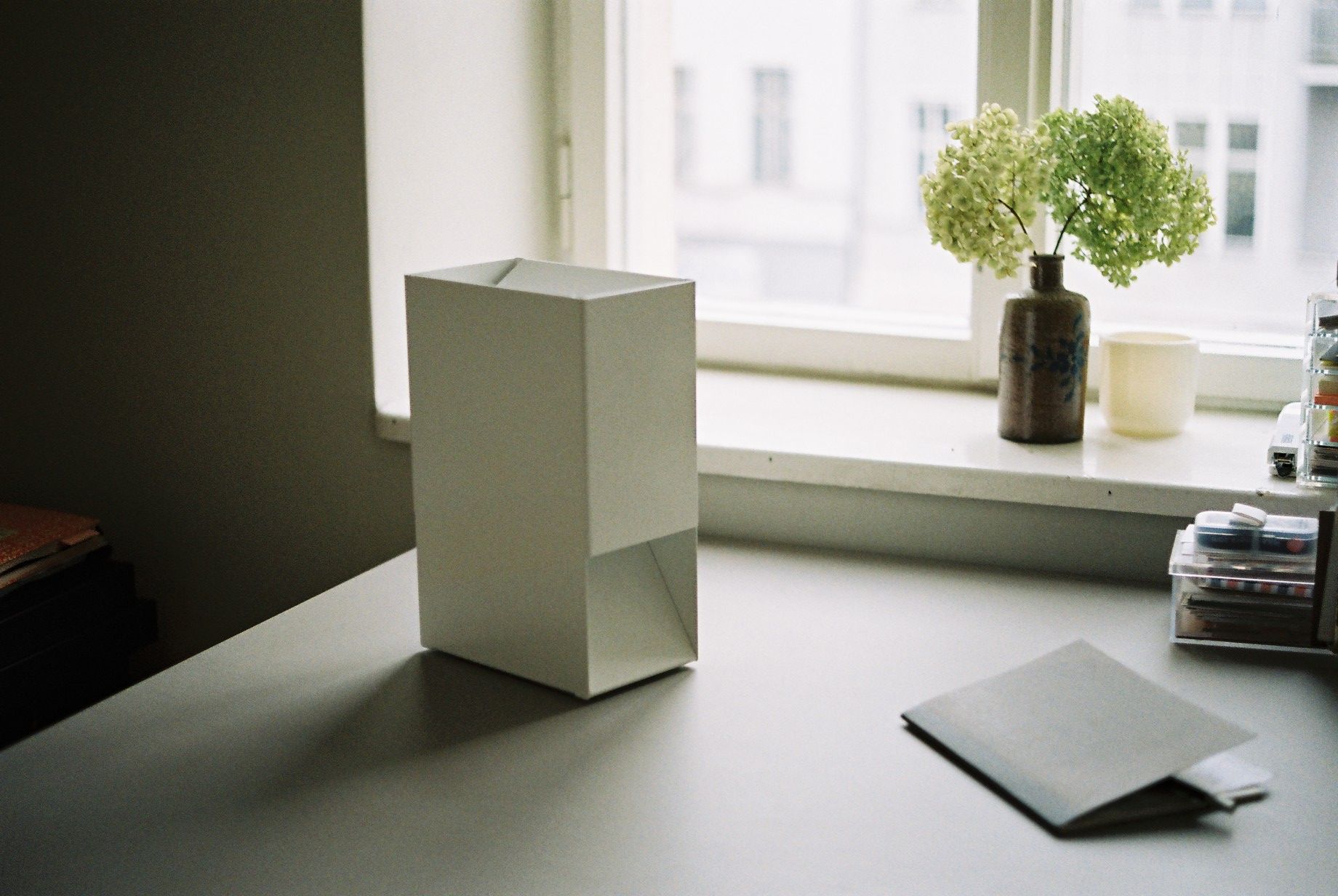 Weiße Linea1 Tischleuchte von Müller Möbelwerkstätten auf einem Schreibtisch, minimalistisches Design für modernes Wohnen.