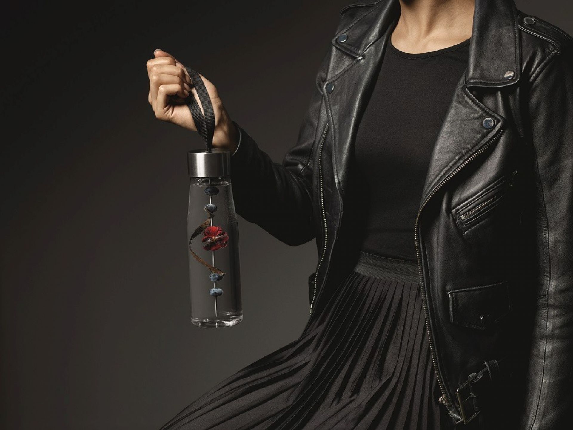 Frau hält MyFlavour Trinkflasche von Eva Solo, gefüllt mit Früchten, in der Hand.