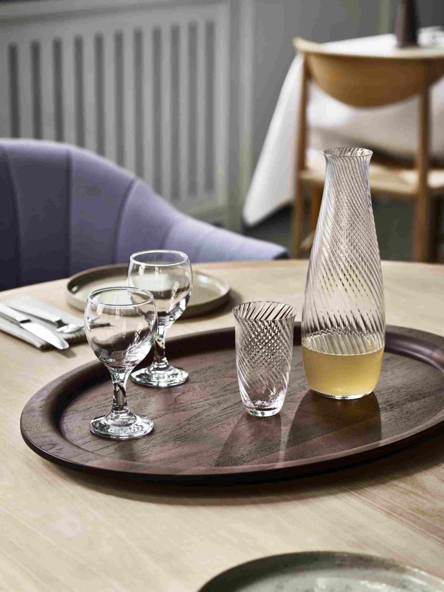 AndTradition Tray SC64-SC65: Ovales Holztablett mit Gläsern und Karaffe auf einem Tisch arrangiert.