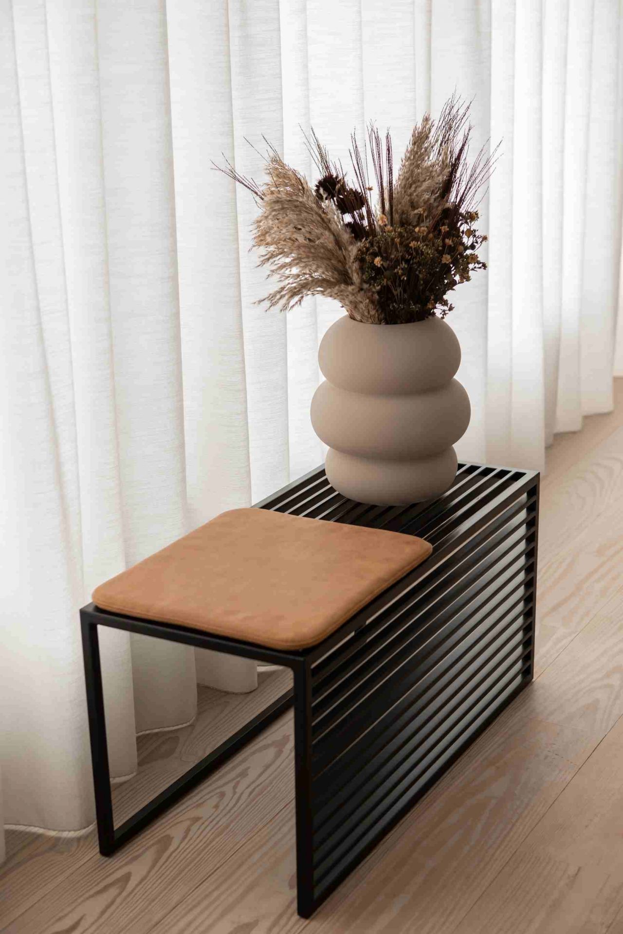 Element Bench Bank novoform mit braunem Sitzkissen und dekorativer Vase im minimalistischen Interieur.