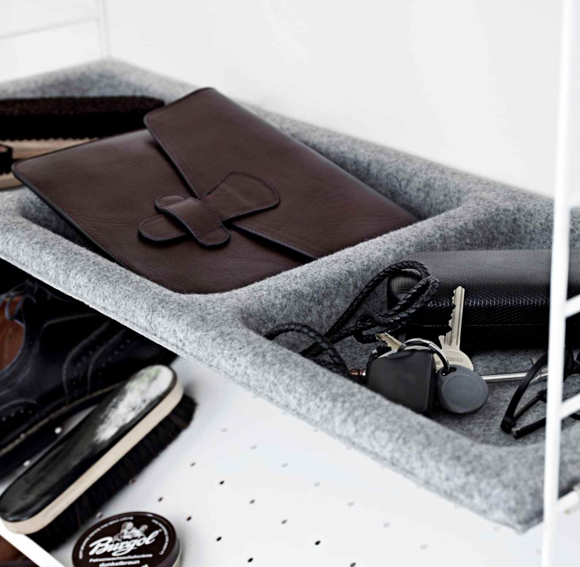 String Sideboard: Grauer Filzeinsatz mit Ledermappe, Schlüsseln und Schuhputzzeug für Schlafzimmer Ordnung.