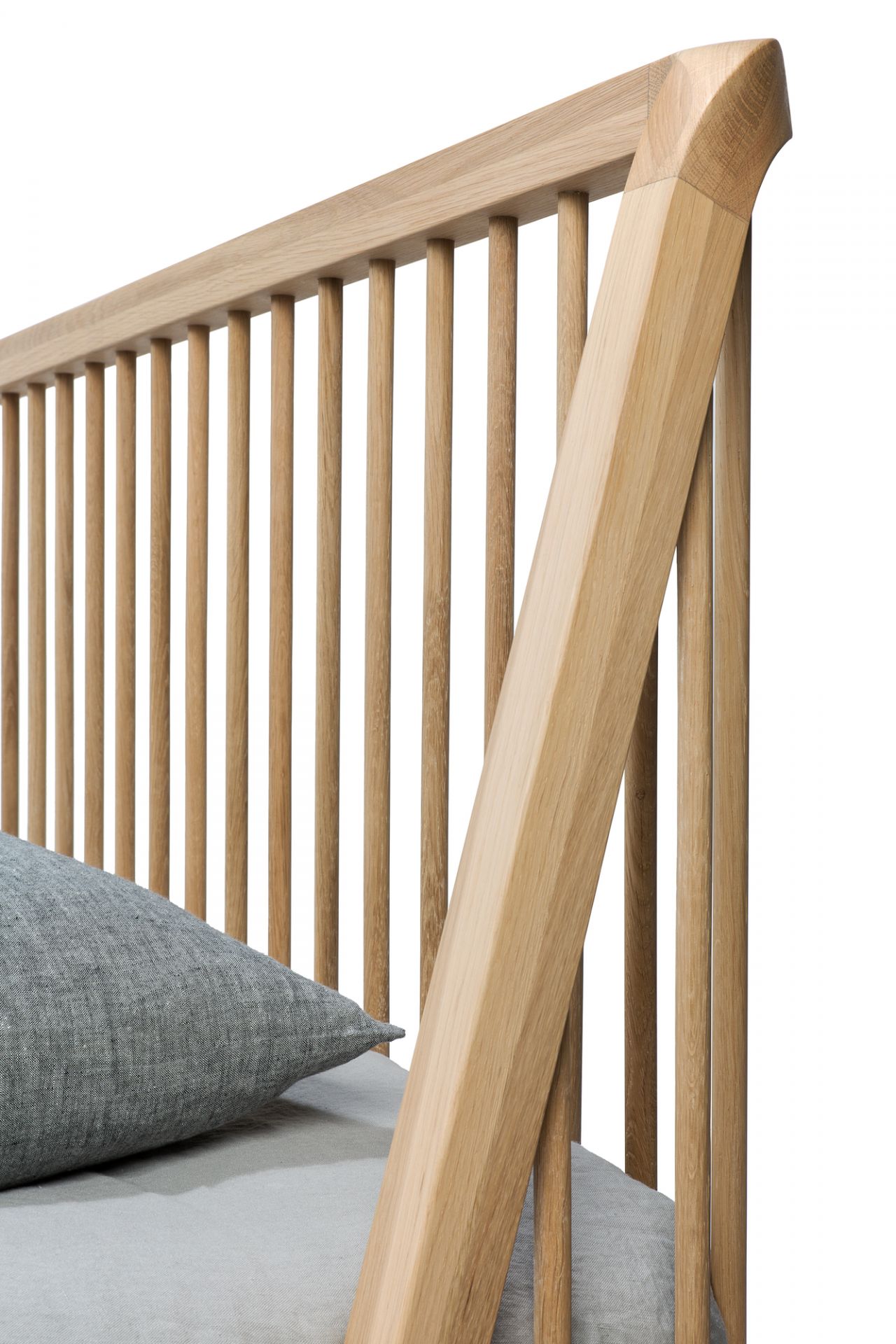 Detailaufnahme: Ethnicraft Spindle Bett aus Eiche mit Lattenrost und grauem Kissen. Massivholzbett für Schlafzimmer.