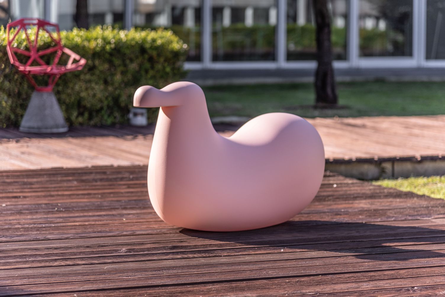 Rosa Dodo Schaukelvogel von Magis für Kinder, modernes Design, auf Holzterrasse.