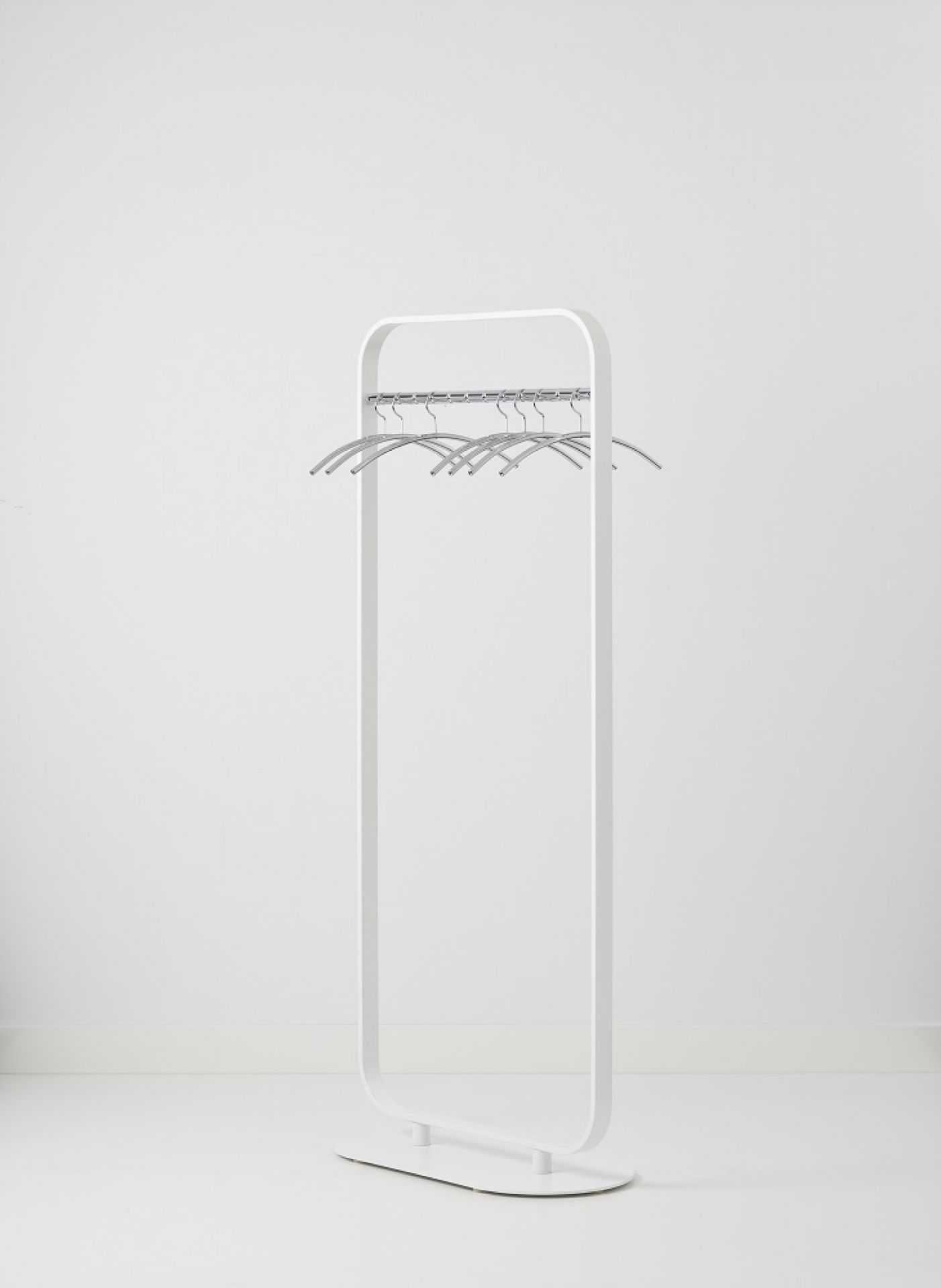Weiße Focus Standgarderobe von Cascando mit silbernen Kleiderbügeln vor einem weißen Hintergrund. Moderne Garderobenlösung für Büro und Zuhause.