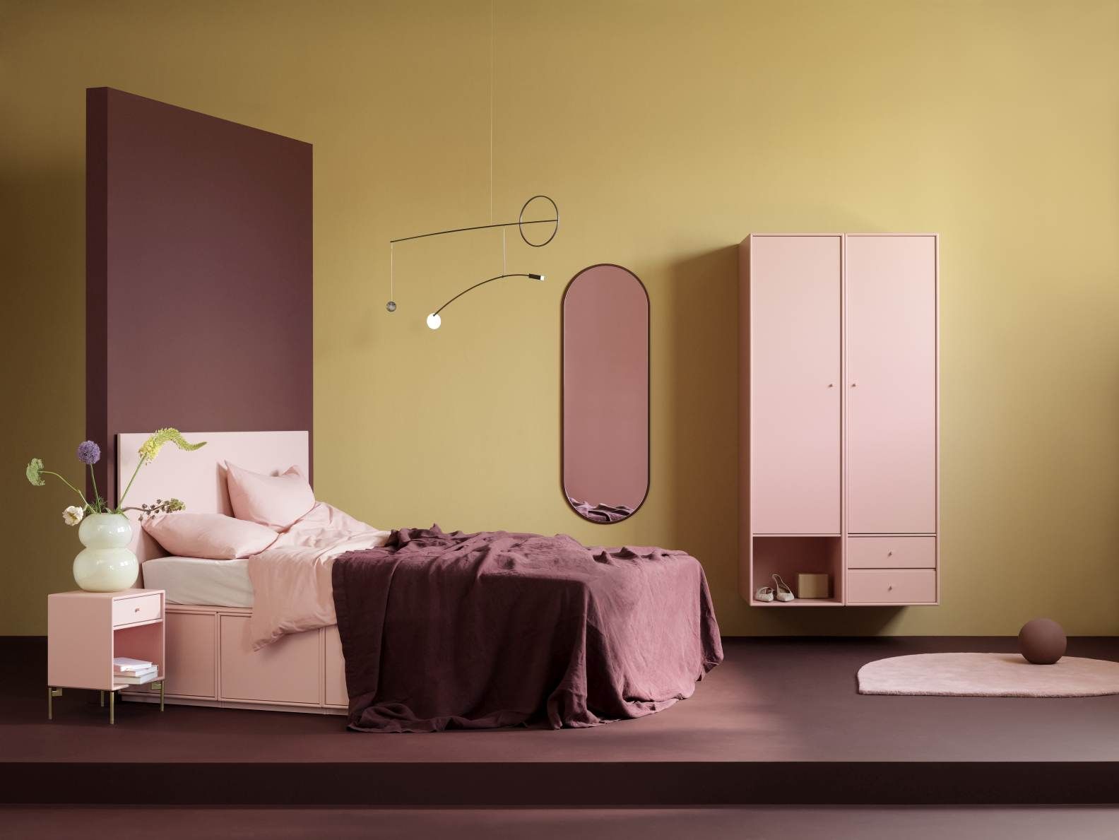 Ovale Colour Frame Spiegel Figur Montana Oyster in rosa Schlafzimmer-Szene mit Bett und Schrank.