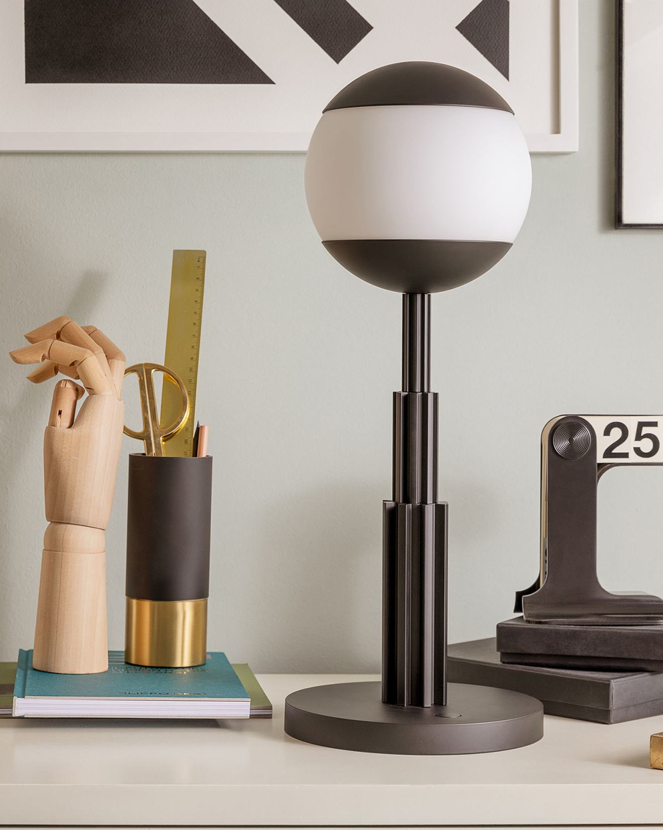 Graue Alessi AR04 Akku-Tischleuchte auf einem Tisch, moderne Lampe für Wohnraum und Büro.