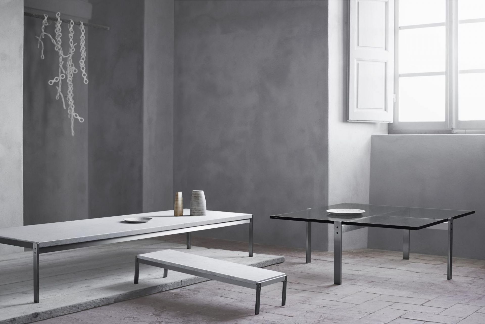 PK65 Couchtisch von Fritz Hansen: Moderner Glastisch und Marmortisch mit Stahlgestell im Interieur.