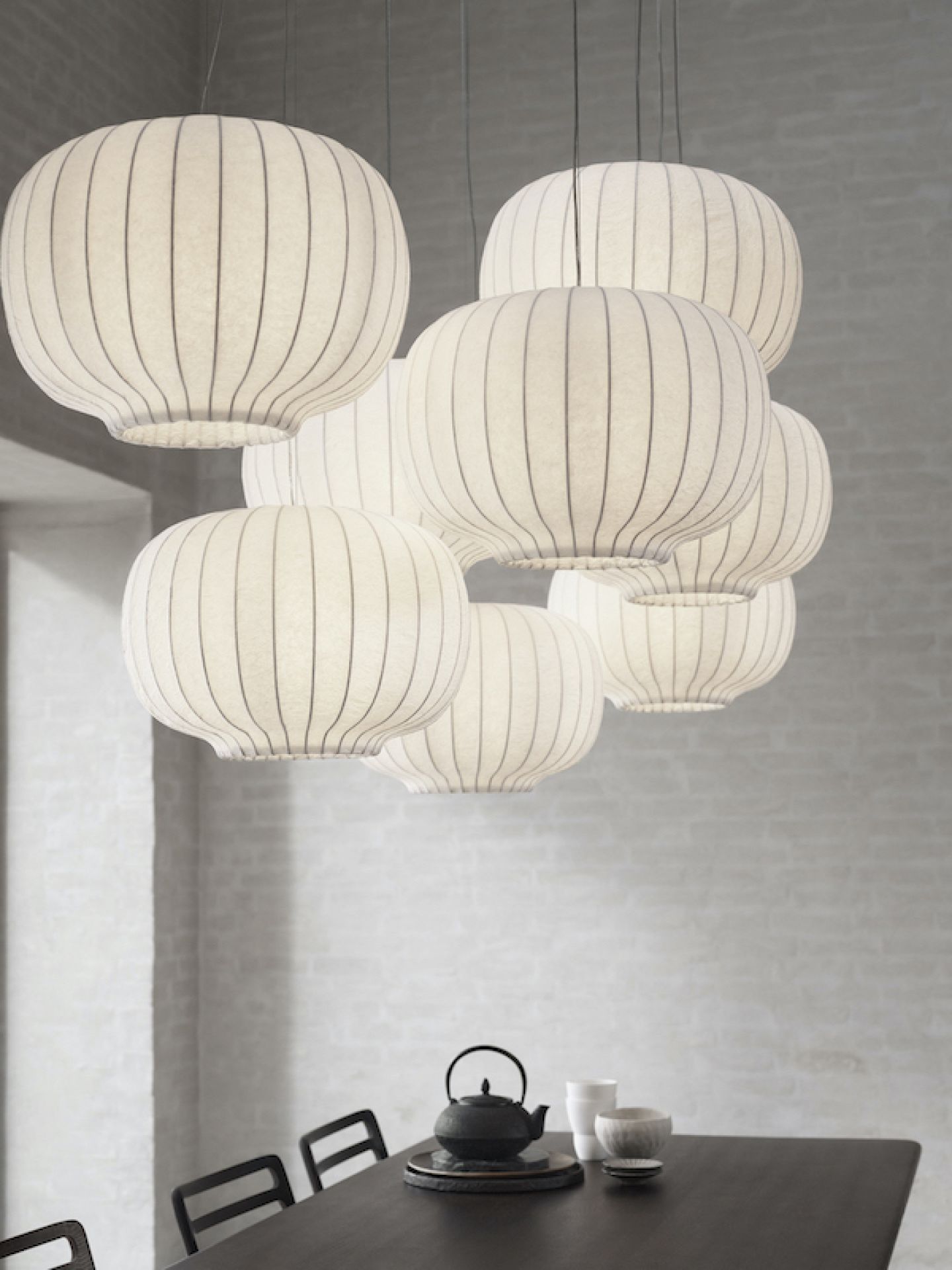 Mehrere Vipp Paper Pendant Pendelleuchten in Eiche Dunkel hängen über einem Esstisch.