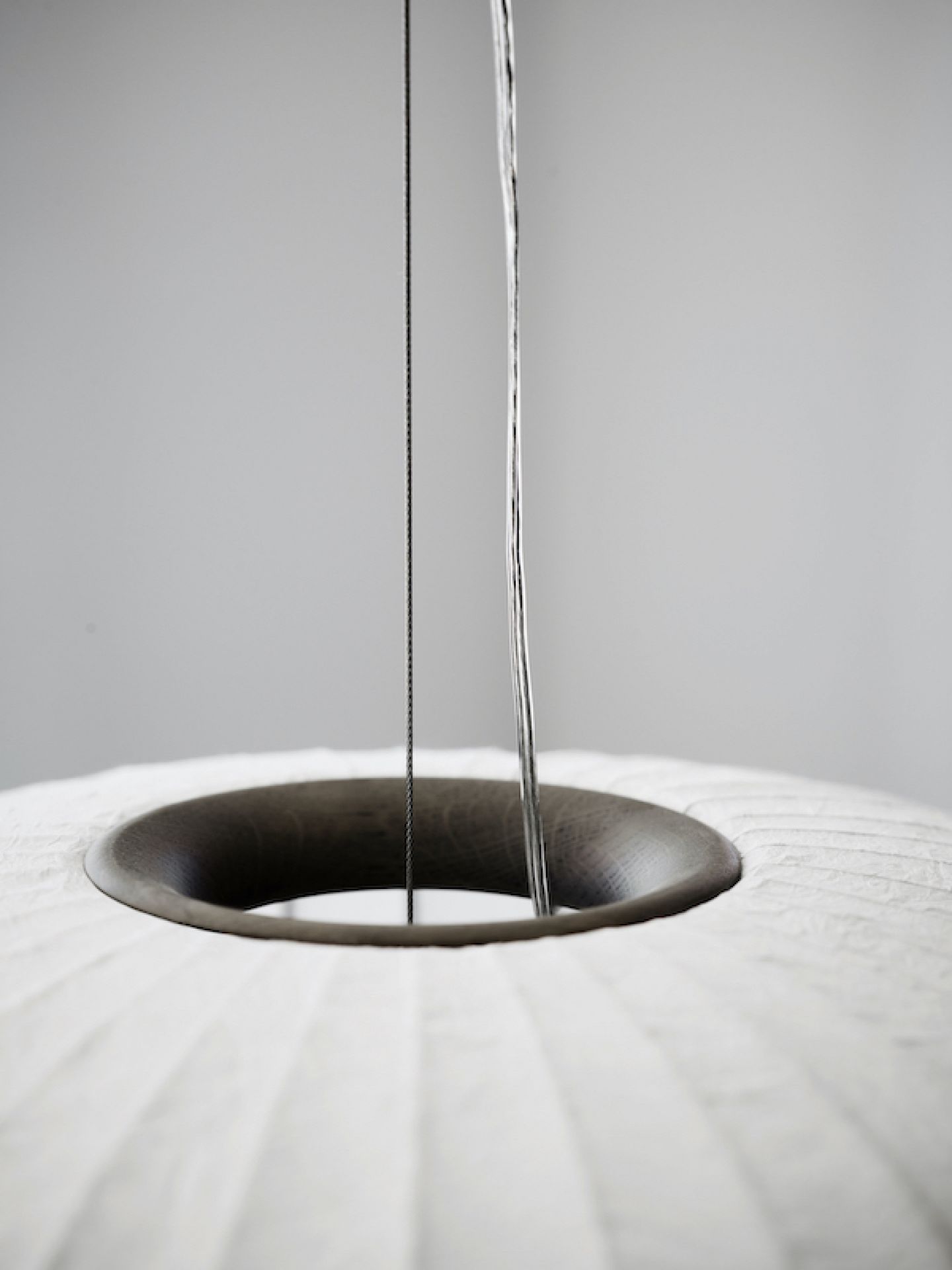 Detailaufnahme der Vipp Paper Pendant Pendelleuchte mit dunklem Eichenholzring und Papier Lampenschirm.