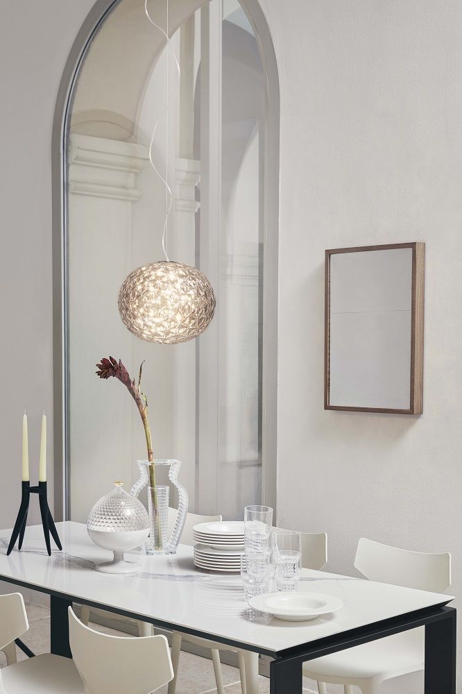 Planet Pendelleuchte von Kartell über Esstisch mit Geschirr und Dekoration. Design Lampe für Esszimmer.