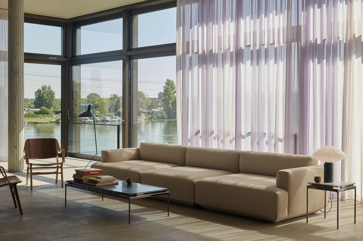 Wohnzimmer mit AndTradition Sett LN11 Beistelltisch neben Sofa und Lampe, minimalistisches Design.