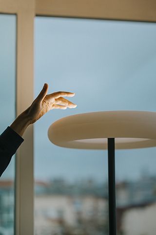 Oto Stehleuchte in Schwarz mit Multisensor, Hand berührt das Licht. Moderne Stehlampe.