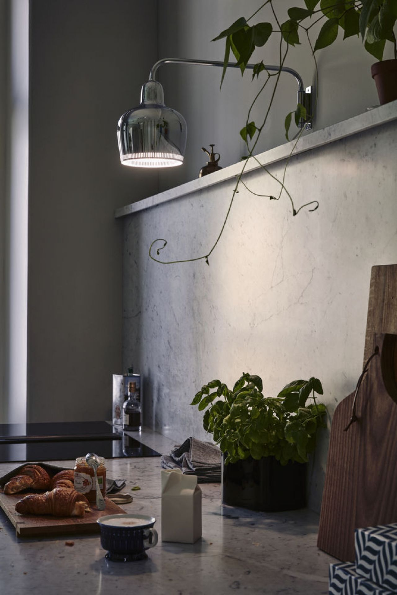 Nahaufnahme der Artek A330S Golden Bell Wandleuchte in Chrom über einer Küchentheke.