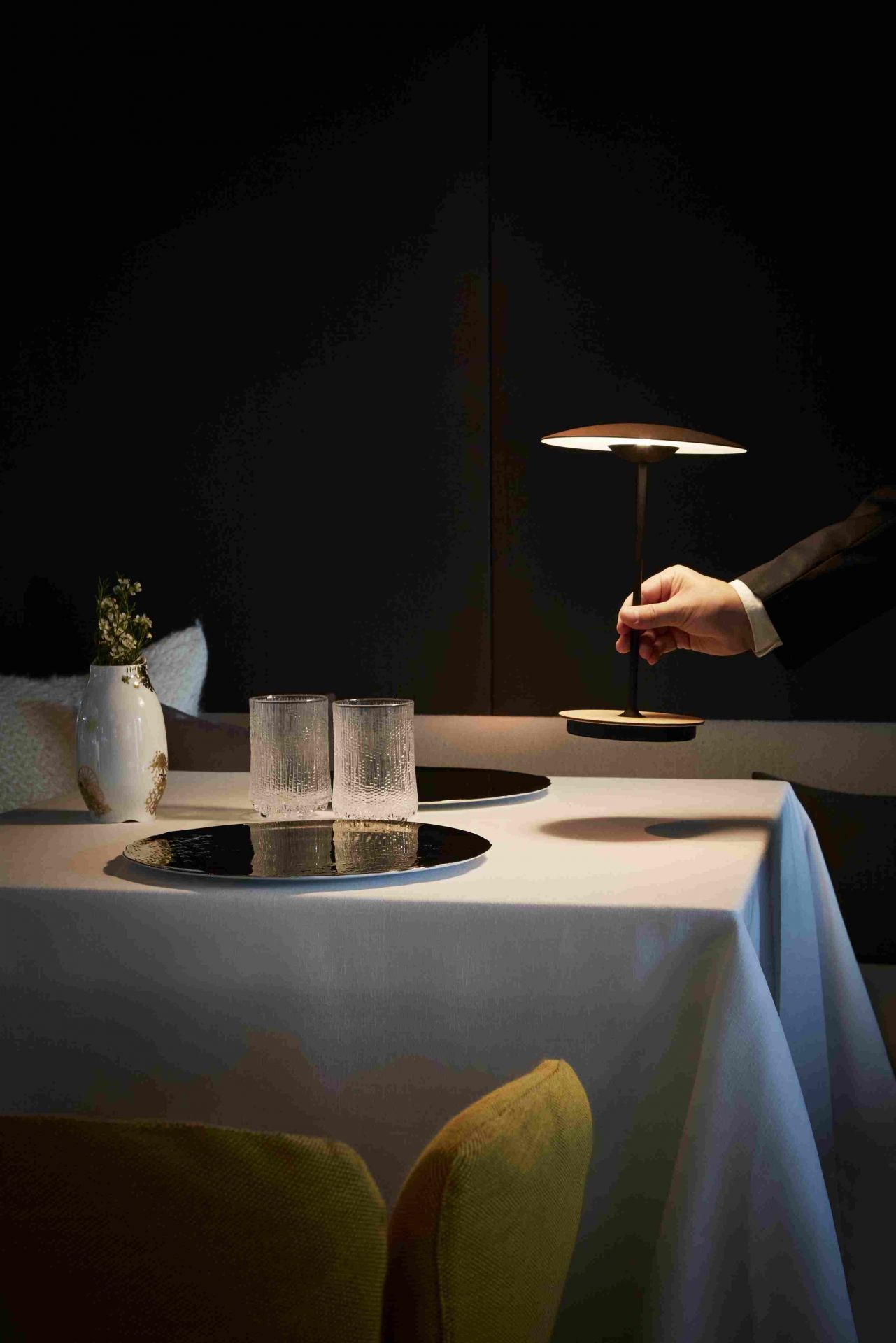 Ginger 20 M LED Akkuleuchte Eiche auf gedecktem Tisch, warmes Licht, elegante Tischleuchte.