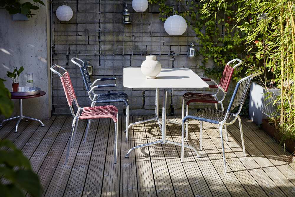 Altorfer Sessel Outdoor Embru Graphitschwarz: Gartenmöbel-Set mit Stühlen und Tisch auf einer Holzterrasse.