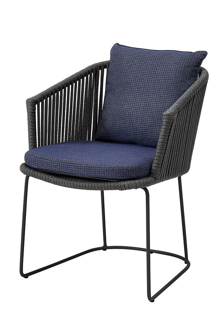 Hellgrauer Cane-Line Moments Stuhl mit blauem Sitzkissen und Rückenkissen für den Outdoor-Bereich.