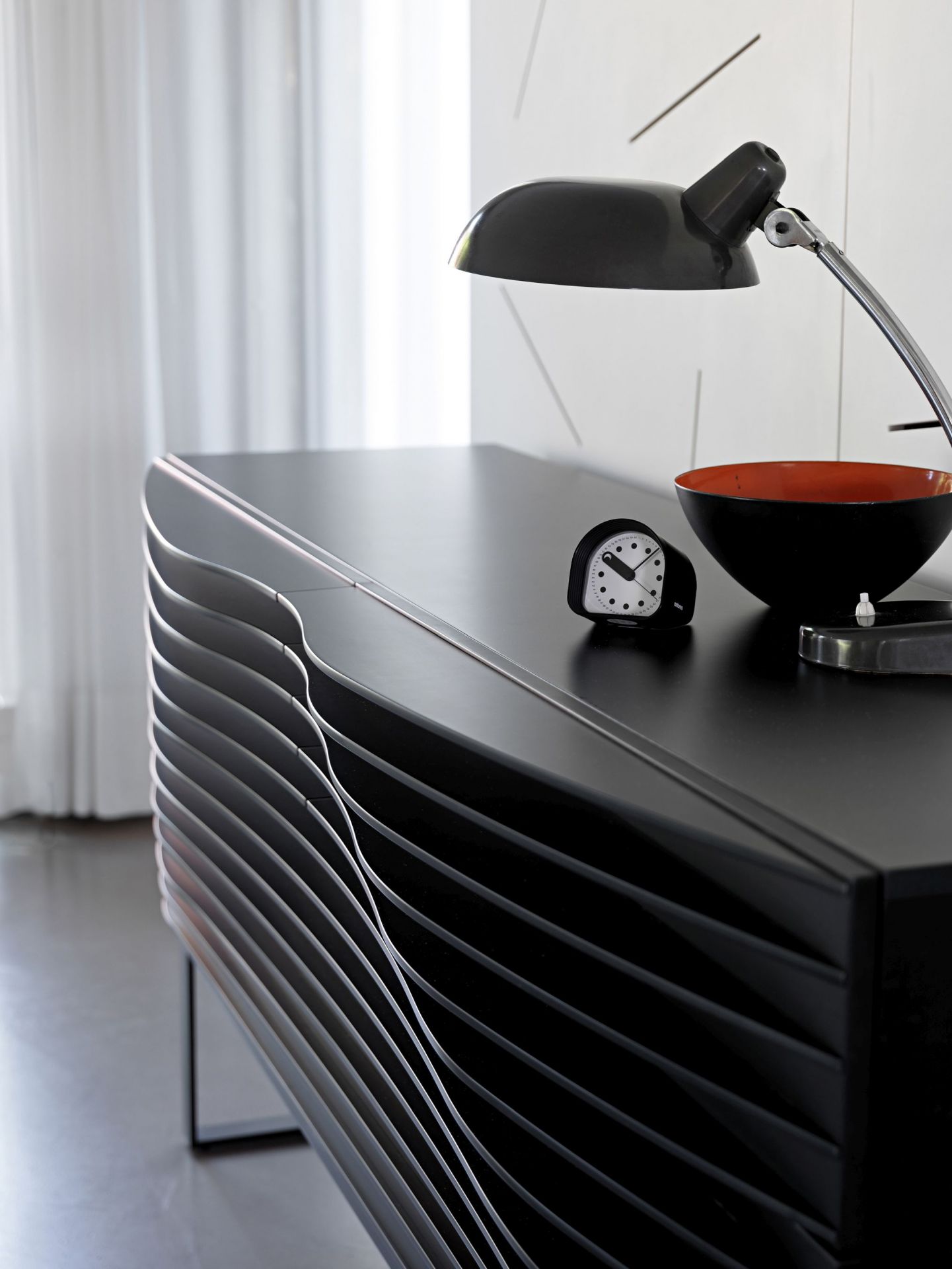 Tide Anrichte von Casamania Horm, schwarzes Sideboard mit minimalistischem Design und Lampe.