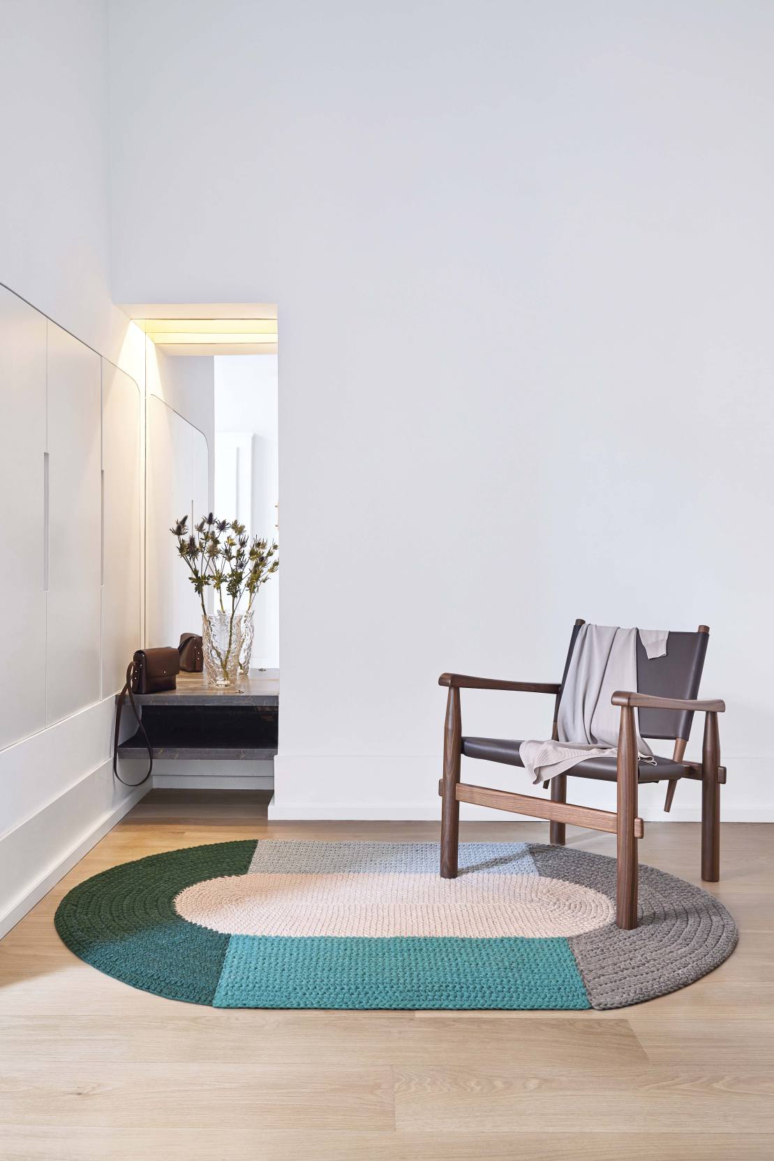 The Crochet Collection Teppich in Beige mit Farbblöcken und Stuhl im modernen Raum.