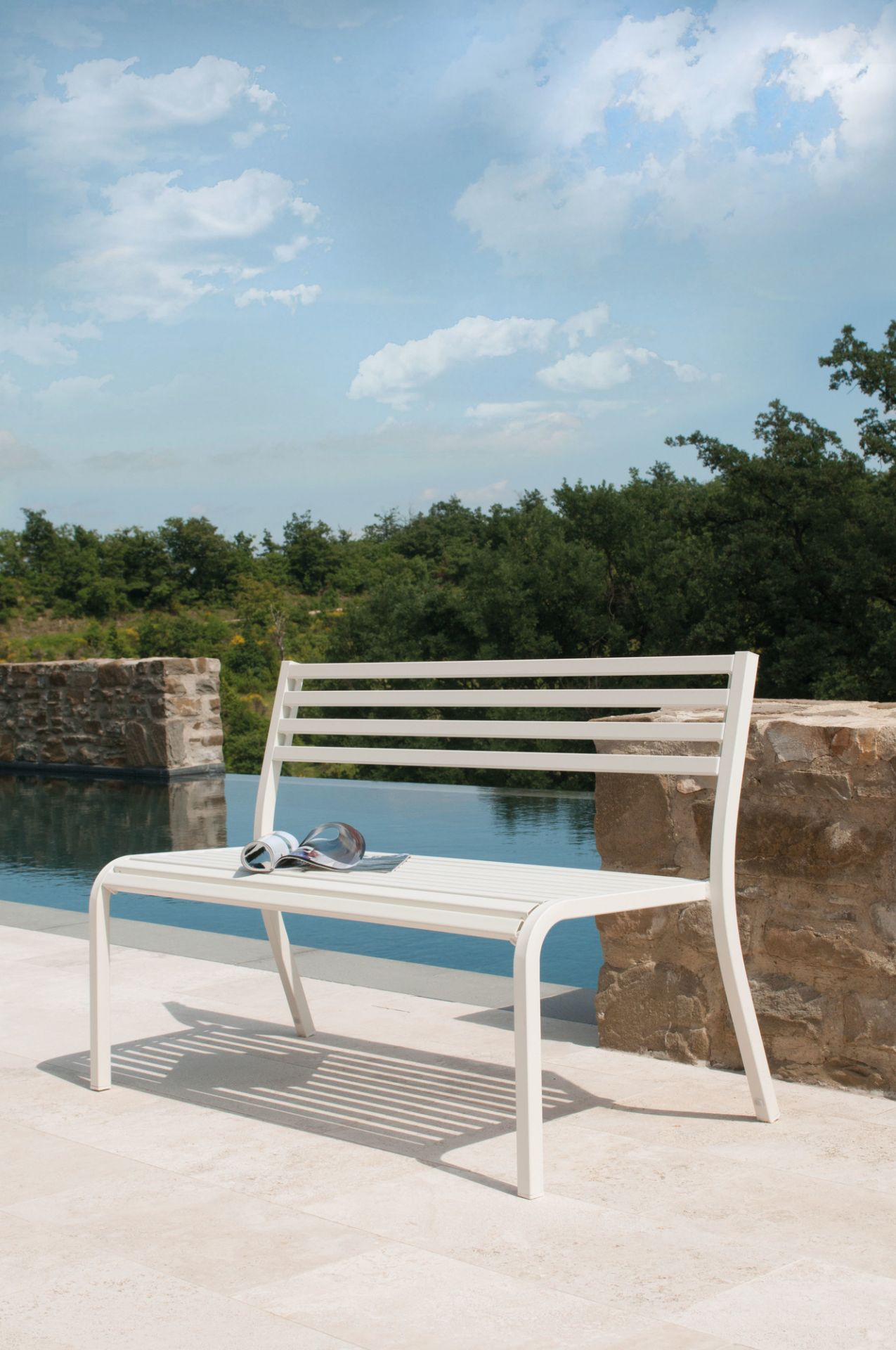 Weiße Emu Bank Segno 128 cm im Außenbereich mit Pool und Magazin. Gartenmöbel.