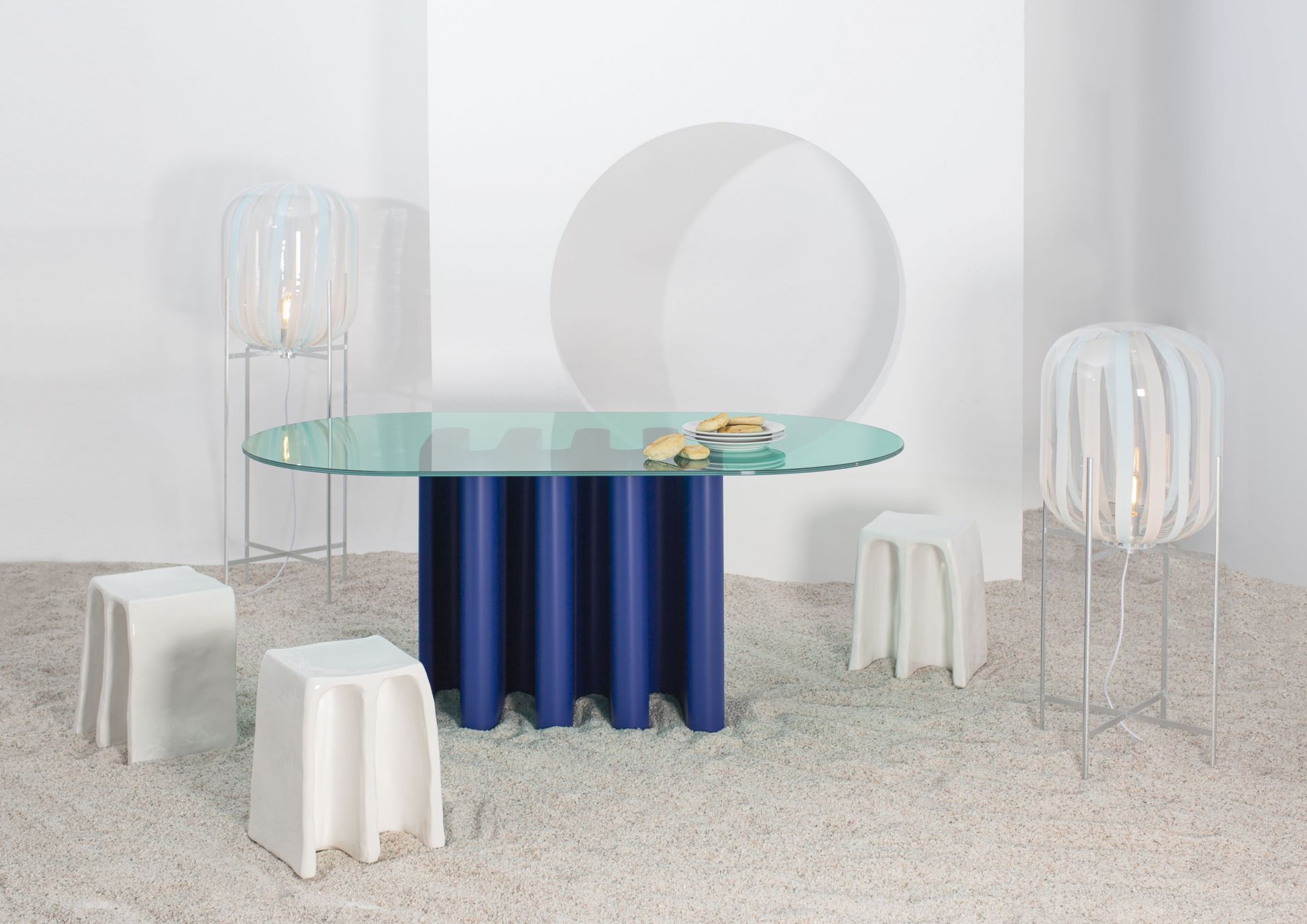 Tavolo2 Esstisch von Pulpo mit Glasplatte und blauem Säulenfuß in minimalistischem Ambiente.