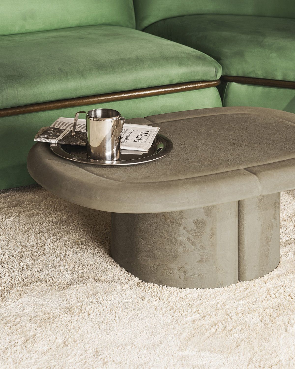 Ovaler Alder Lounge Couchtisch von Mater, grau, mit Zeitung und Krug auf einem Tablett.