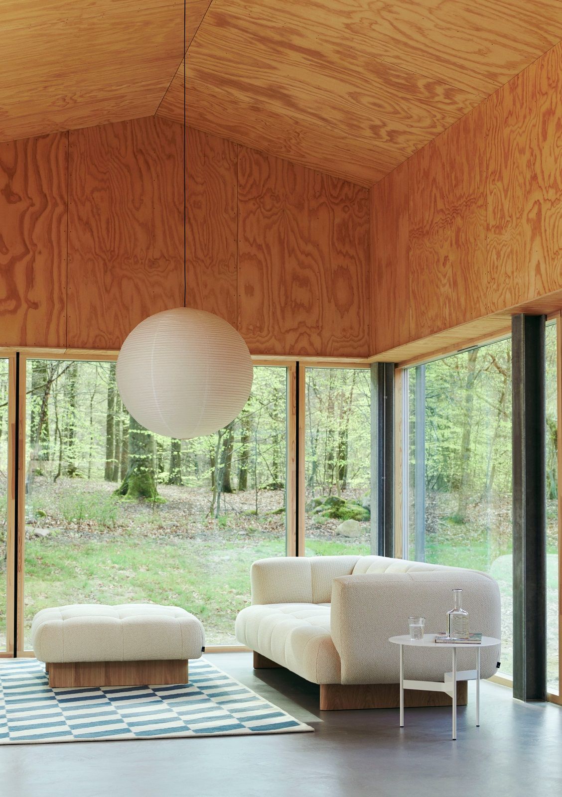 Beiger Quilton Ottoman Hocker von Hay im modernen Wohnzimmer mit Sofa und Teppich.