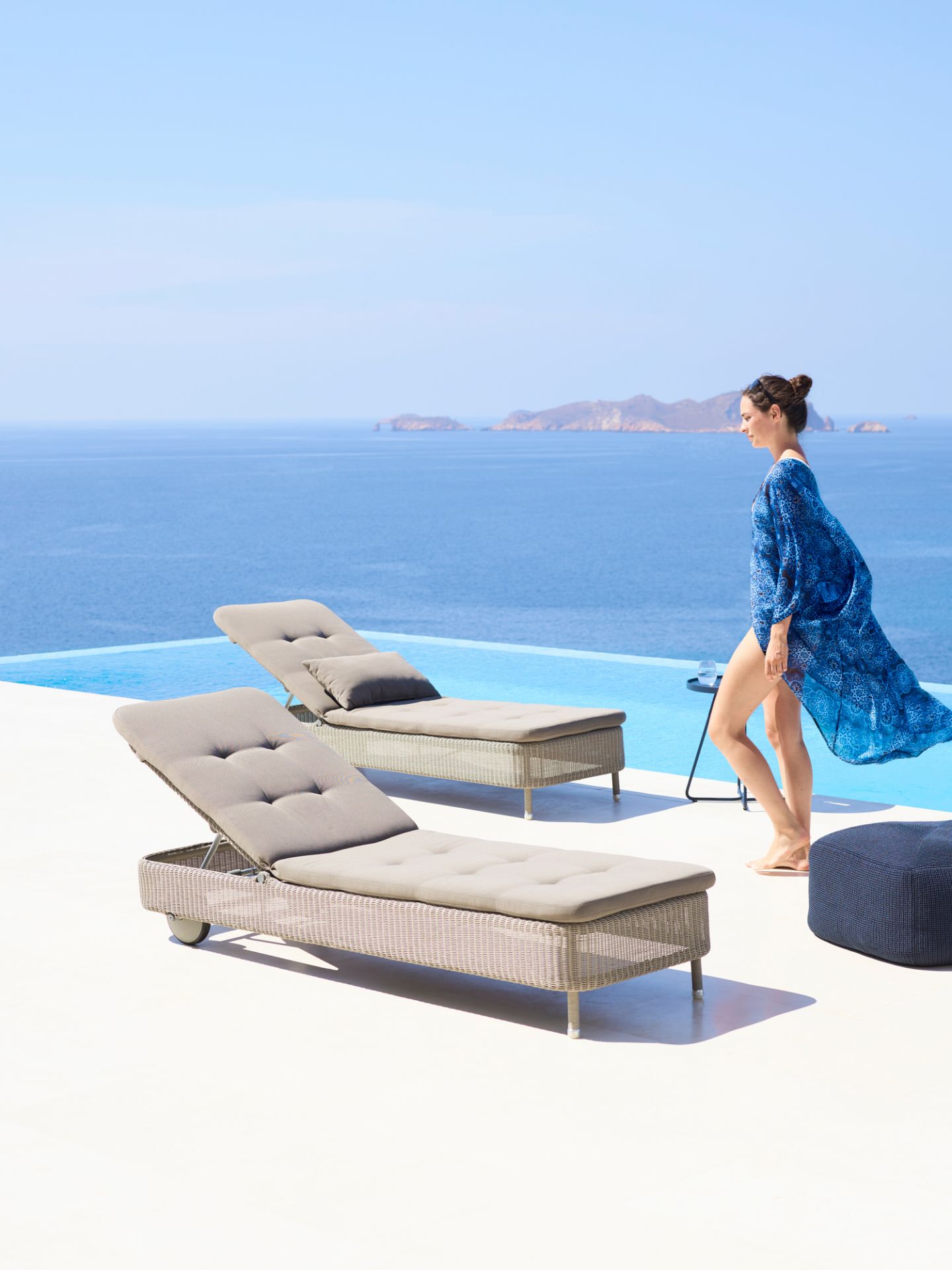 Presley Outdoor Sonnenliege Cane-Line in Taupe am Pool mit Meerblick. Hochwertige Gartenmöbel für Entspannung.