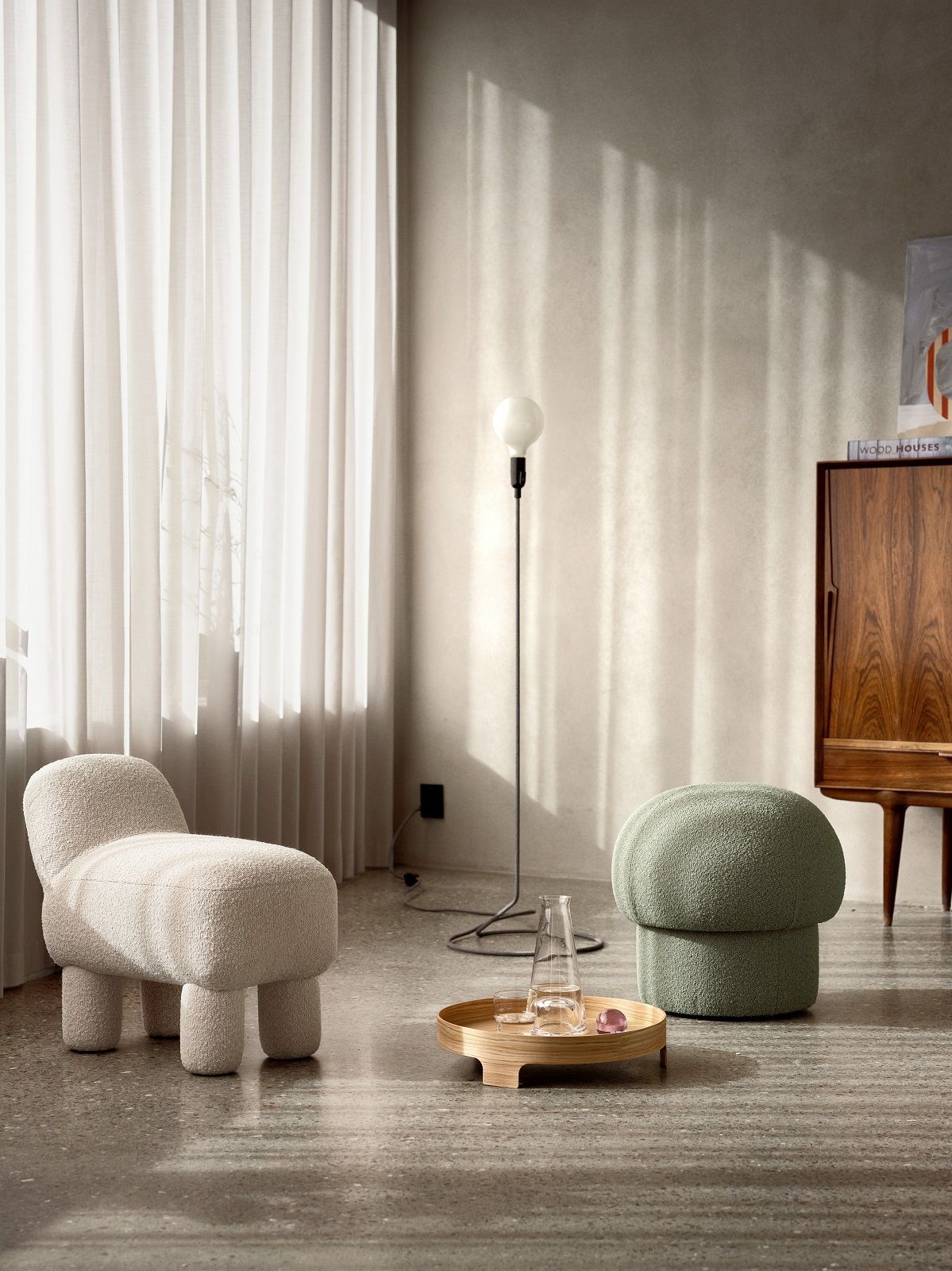 Wohnzimmer-Szene mit grünem Uno Pouf Hocker von Design House Stockholm und beigem Sessel.
