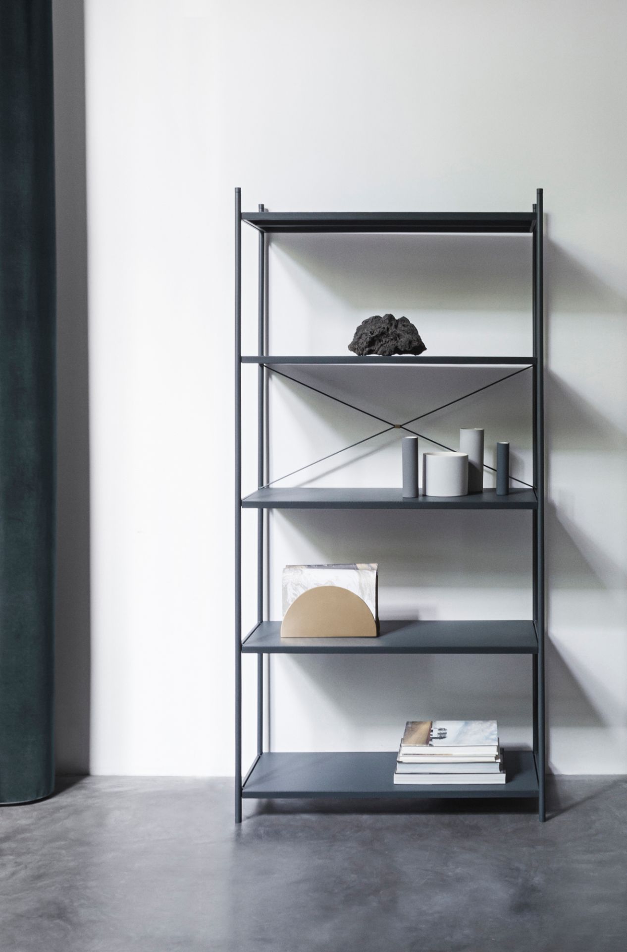 Graues Punctual Regal von Ferm Living mit fünf Fächern und Deko-Elementen vor weißer Wand.