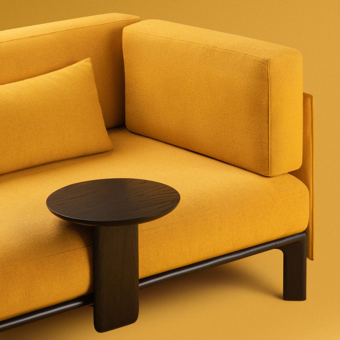 Anagram Anstecktisch von Vitra, runde Tischplatte aus dunklem Holz, neben gelbem Sofa.