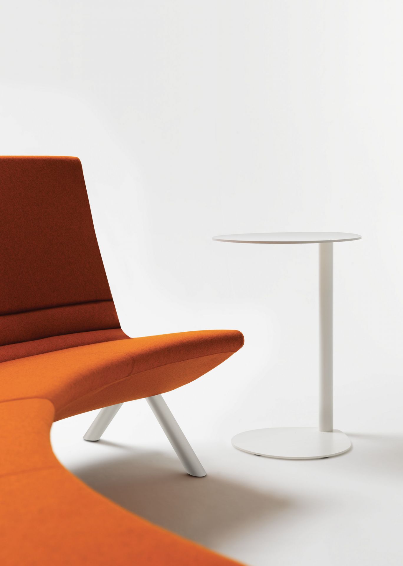 Weißer Easy Boy Beistelltisch von Segis neben einem orangefarbenen Sessel auf weißem Hintergrund.