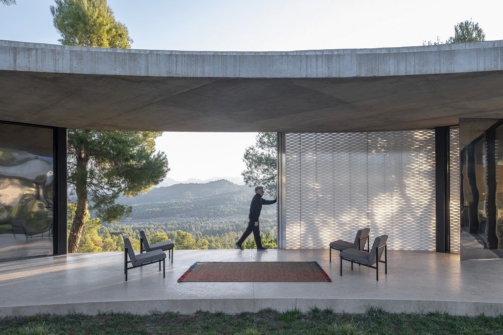 Nanimarquina Re-Rug Collection Teppich 200x300 cm in modernem Ambiente mit Person und Stühlen.