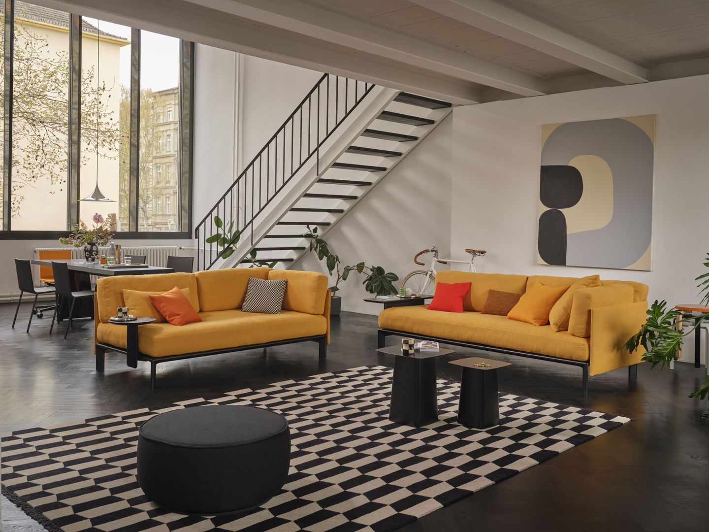 Wohnzimmer mit gelben Sofas und Vitra Anagram Anstecktisch, runder Beistelltisch in Schwarz.