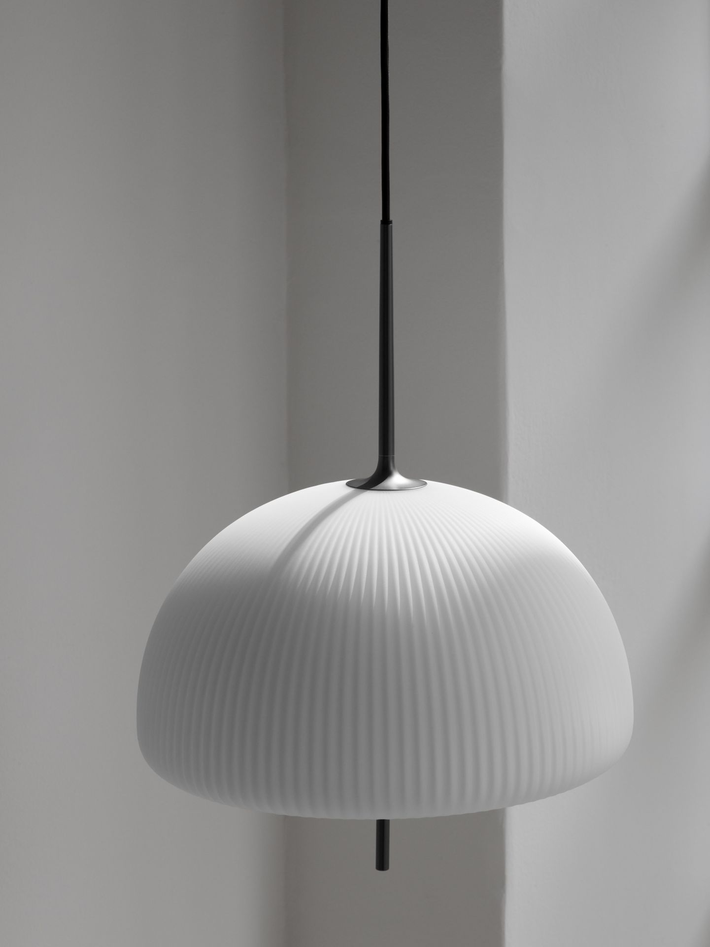 Nahaufnahme der Vipp Sculpture Pendelleuchte: Weißer Lampenschirm mit geriffelter Oberfläche und schwarzer Aufhängung.