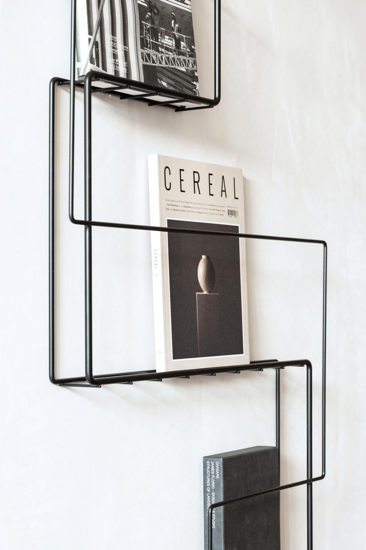 Schönbuch Revue Wand Zeitungsständer aus schwarzem Metall mit Zeitschriften und Büchern. Modernes Wandregal für Magazine.