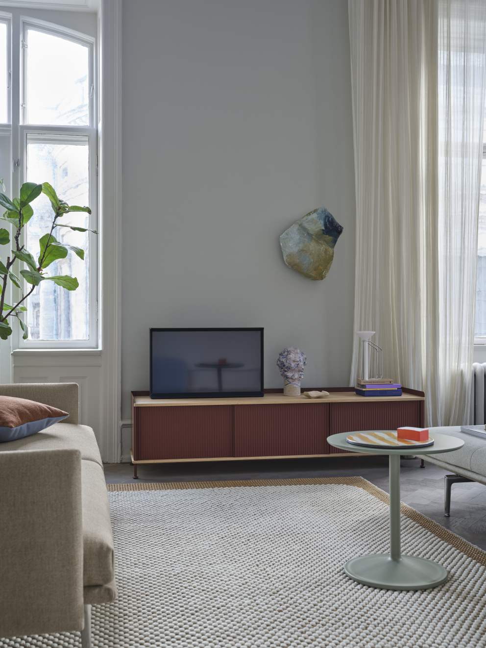Wohnzimmer mit Muuto Enfold Sideboard Low in Rotbraun unter einem Fernseher.