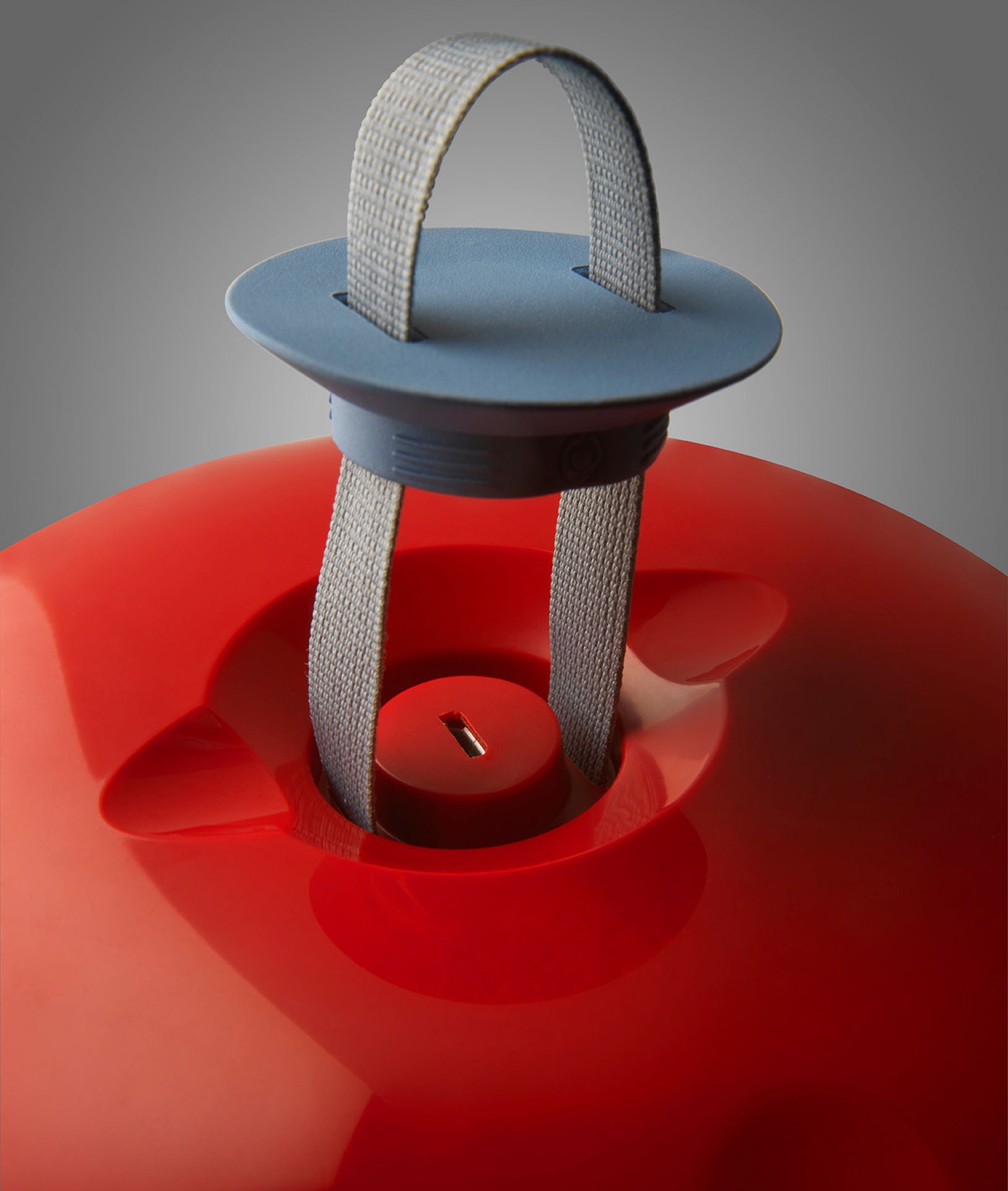 Detailaufnahme der roten Cri Cri Tischleuchte von Foscarini mit Tragegriff. Design Lampe für Innenräume.