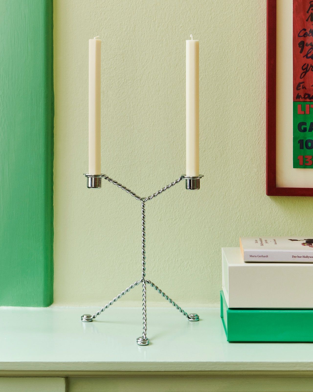 Hay Wire Candleholder Kerzenständer mit zwei weißen Kerzen auf einem mintgrünen Tisch, minimalistisches Design.