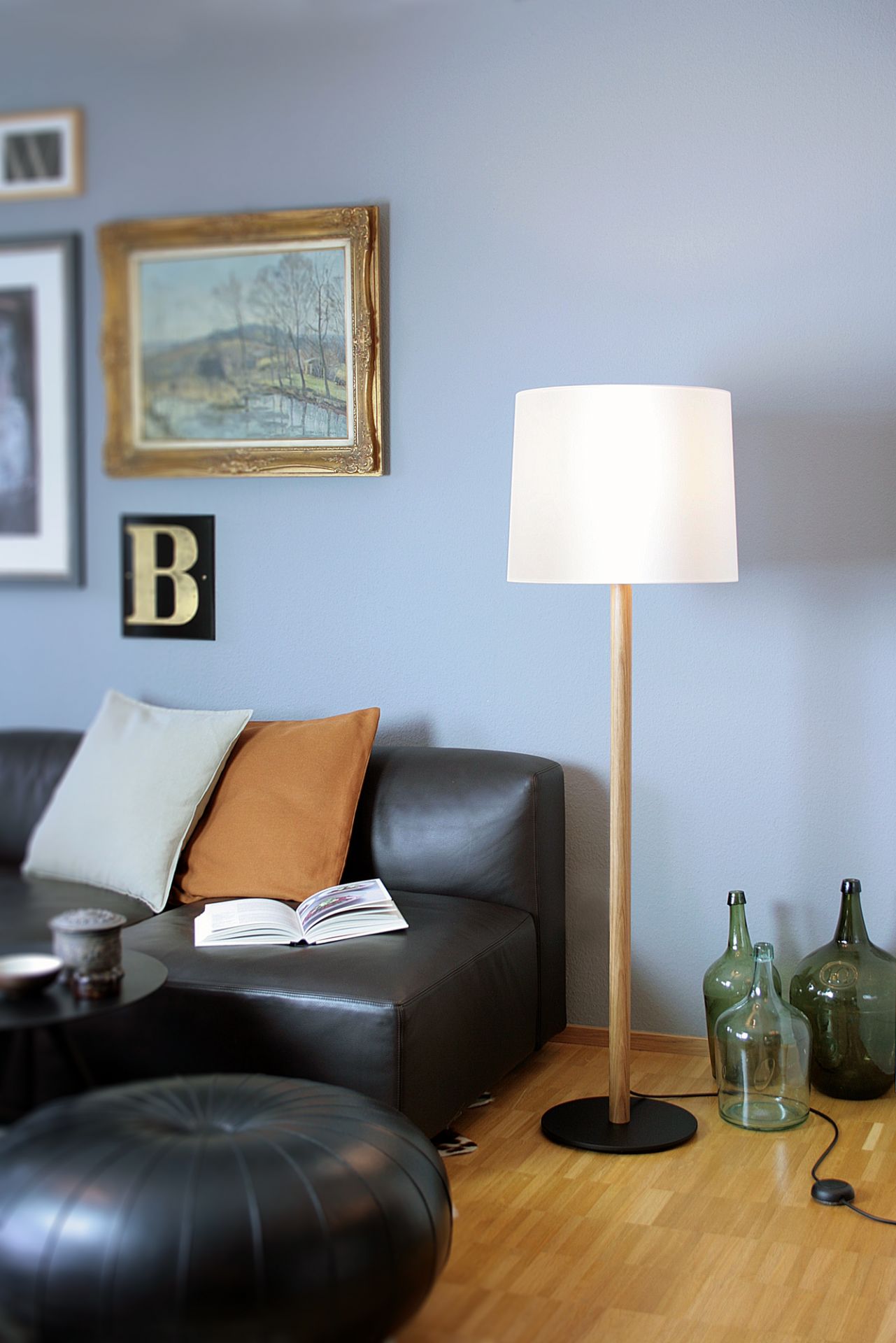 Miyu Stehleuchte aus Eiche geräuchert mit naturweißem Filzschirm im Wohnzimmer. Moderne Bodenleuchte für gemütliches Licht.