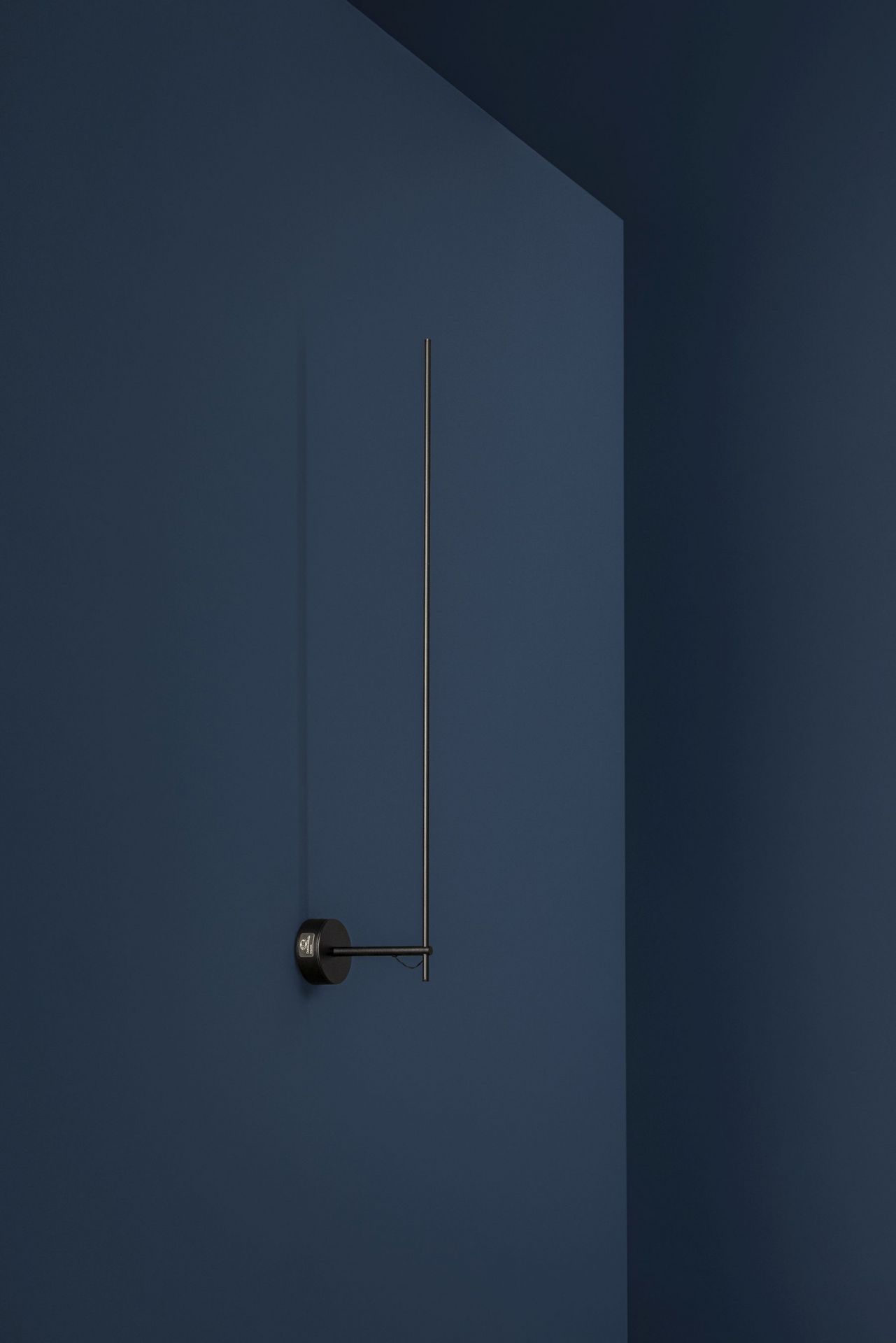 Schlichte Light Stick Wandleuchte von Catellani & Smith an blauer Wand. Moderne Innenbeleuchtung.