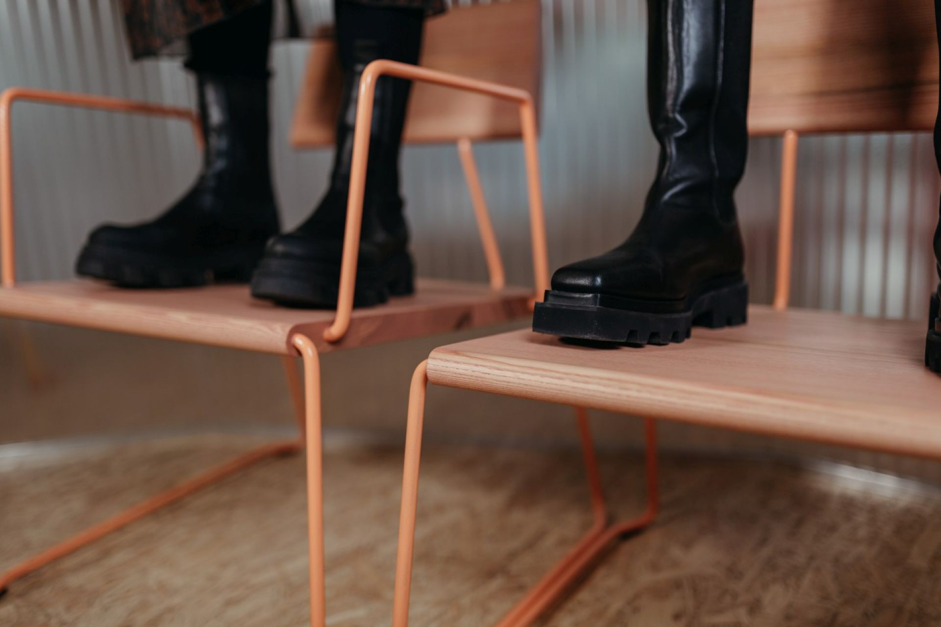 Nahaufnahme: Schwarze Stiefel auf D:007 Loungechair von Fuchs & Habicht, modernes Möbeldesign.