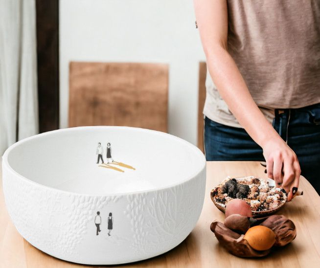 Weiße Räder Schale "Parkspaziergang" mit filigranem Muster und Personendarstellung, gefüllt mit Obst und Müsli.